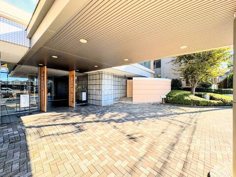 建物前の屋根付きアプローチと植栽