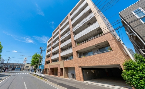 道路沿いに建つ、バルコニー付きの中高層住宅
