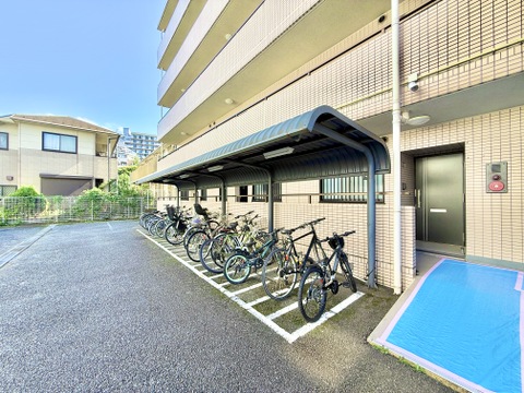 屋根付きの駐輪スペースと建物外観
