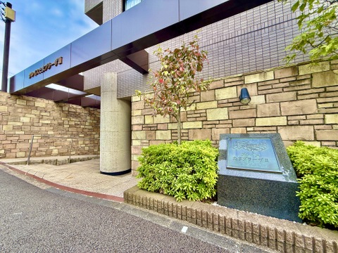 石張りの外壁と植栽がある建物入口付近