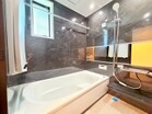 大理石調のアクセントパネルとシックな色調がバスタイムに気品を。