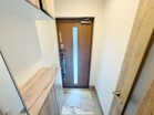 扉のスリットから自然光が入り、明るい印象の玄関ホール。上下セパレートのシューズボックスで収納力もしっかり確保。